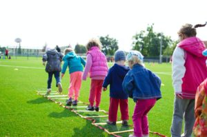 Children playing on a floor ladder outside